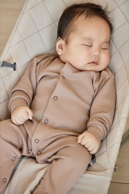 Imagen vertical de un lindo bebé asiático durmiendo en su cama