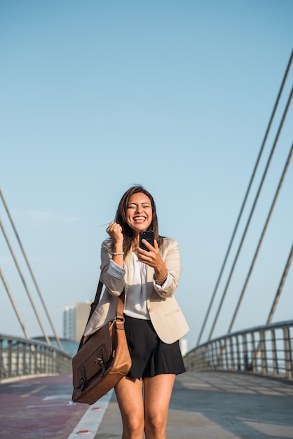 Imagen vertical de una mujer de negocios celebrando con entusiasmo ganar un premio en su teléfono celular Imagen vertical Espacio de copia