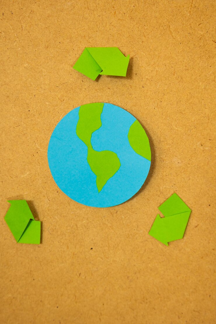 Imagen vertical del planeta Tierra en papel con una señal de reciclaje en un tablero