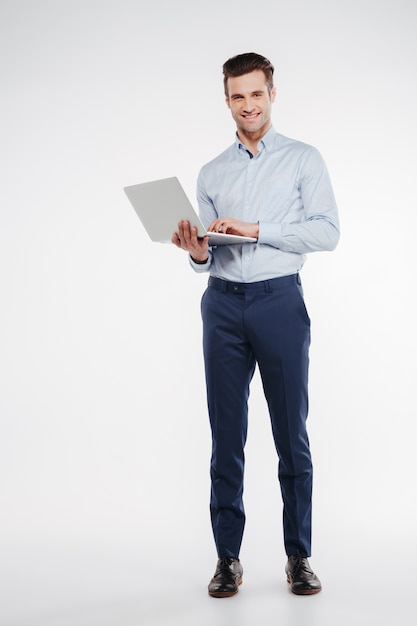 Imagen vertical de sonriente hombre de negocios con ordenador portátil