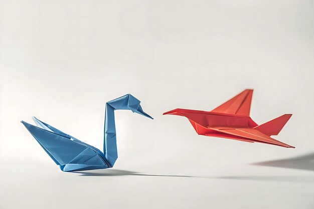 Foto una imagen de un vibrante cisne de origami azul mirando hacia arriba en un avión de papel origami rojo en vuelo contra un fondo blanco limpio