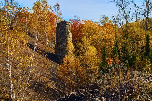 Foto imagen del viejo silo de la mina abandonada visto durante el otoño en una zona boscosa