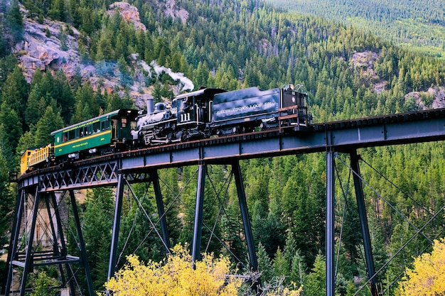 Foto imagen del viejo tren locomotora pasando por el puente en las montañas