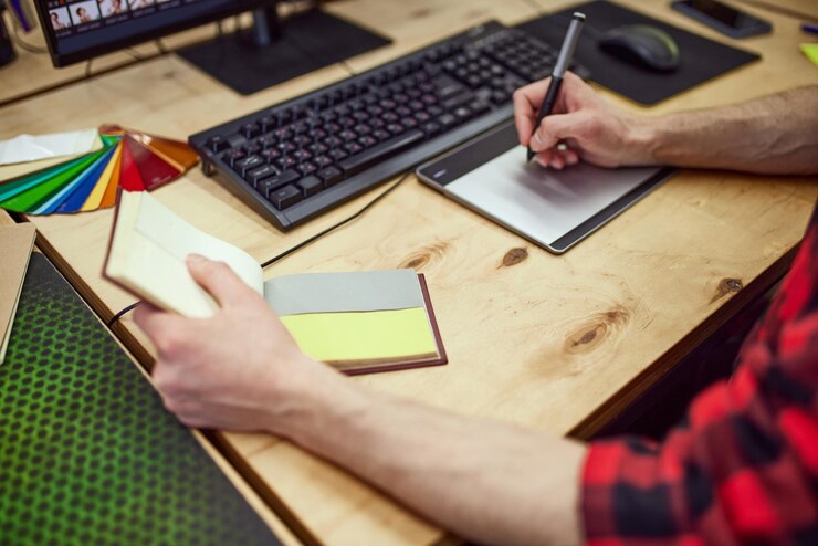 Foto imagen de la vista superior de un diseñador gráfico trabajando con una tableta gráfica utilizando la paleta de colores para hacer bocetos