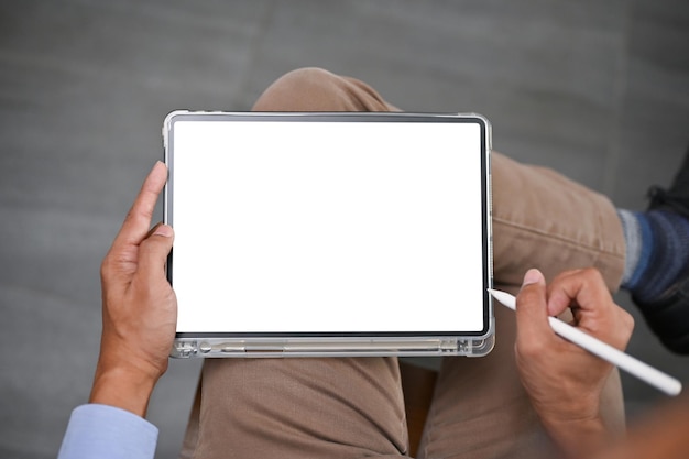 Imagen de la vista superior de un hombre asiático usando su tableta digital en una habitación
