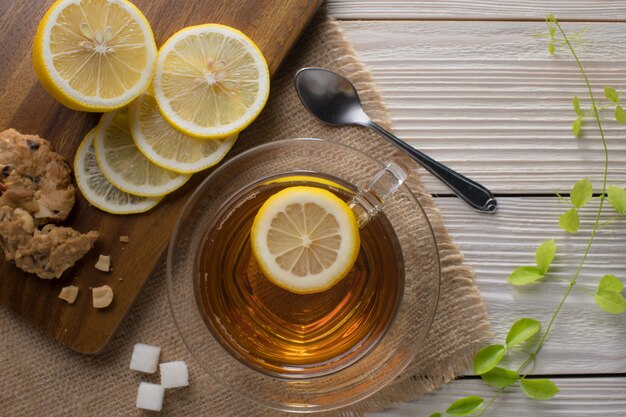 Imagen de la vista superior de una taza de té con limón en la mesa de madera