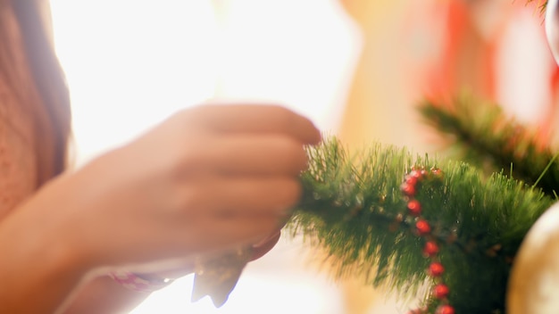 Imágenes 4 de k de mujer joven preparándose para el año nuevo y decorando el árbol de Navidad con bolas. chucherías y juguetes. Casa de decoración familiar en vacaciones y celebraciones de invierno.