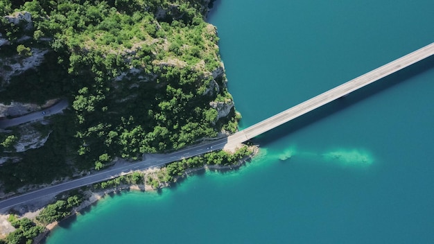 Foto imágenes aéreas de un coche conduciendo sobre un puente en el lago piva