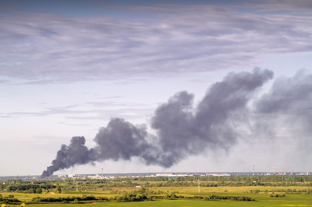 Imágenes de humo contra el cielo de un incendio en la ciudad en el horizonte.