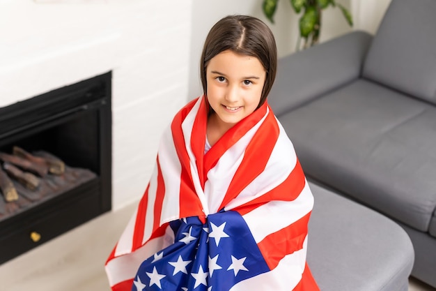 imágenes de una niña encantadora sobre el fondo de la bandera de Estados Unidos.