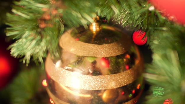 Imágenes panorámicas de primer plano de bolas de oro, adornos y guirnaldas que decoran el árbol de Navidad en casa