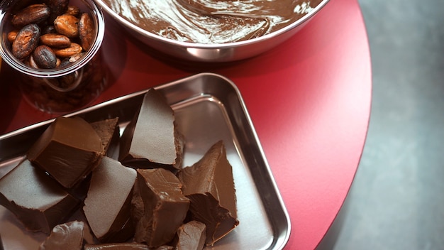 imagens de close do ângulo de visão superior da barra de chocolate e semente de cacau com uma tigela de leite creme marrom escuro