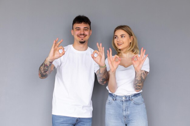 Imagens de feliz animado otimista casal apaixonado posando isolado sobre fundo cinza