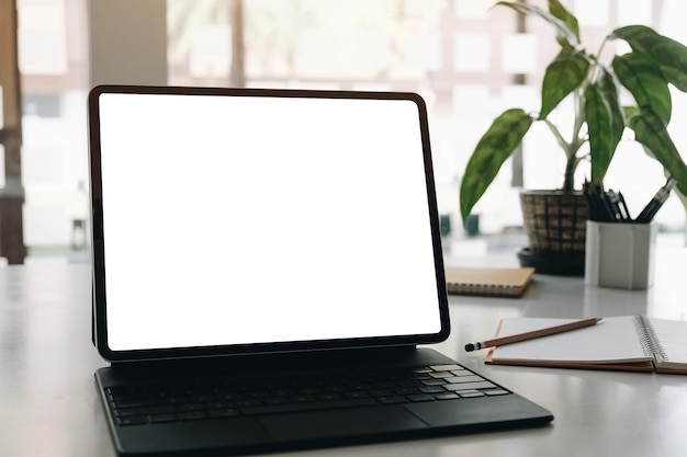 Imita el escritorio de la computadora de pantalla en blanco con teclado en café o fondo de trabajo conjunto