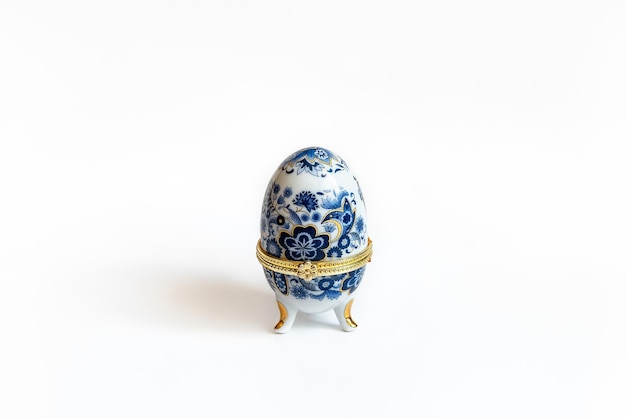 Imitación de la caja de baratijas de joyería de huevo Faberge en colores blanco y azul sobre un fondo blanco