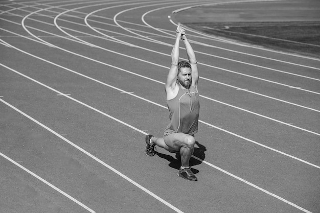 Immer in guter Form Sportler beugen Muskeln im Freien muskulöser Typ dehnen Mann in Yoga-Pose Sport und gesunder Routinesport Erfolg männlicher Athlet macht Morgenübung Aufwärmtraining