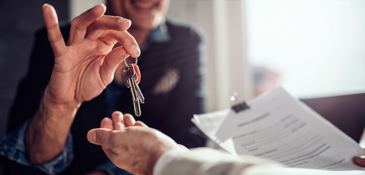 Foto immobilienmakler, der seinem kunden schlüssel übergibt