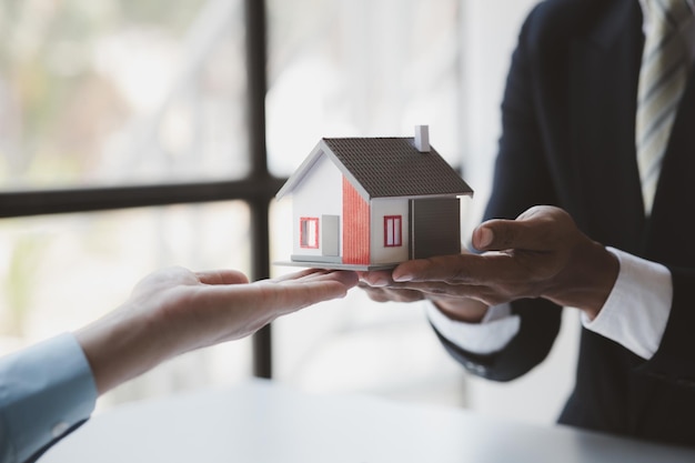Immobilienmakler erklären Modelle von Wohnsiedlungen in Projekten, um Kunden Informationen über Häuser zu erklären und zu präsentieren und Kredite zu kaufen. Immobilienhandelskonzept