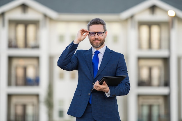 Immobilienmakler Geschäftsmann in Anzug, Halter, Schreibplatten draußen, Hispanic Geschäftsmann, Spezialangebot, Geschäftsgeschäft, Jobangebot, Kaufangebot, Rabattangebot