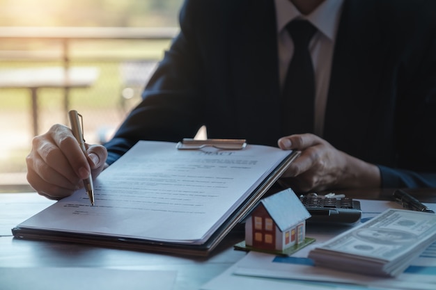 Immobilienmakler gibt Stift- und Dokumentenvereinbarung mit Kunden, um Vertrag zu unterzeichnen.
