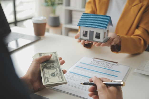 Immobilienmakler liefern eine Probe eines Modellhauses an den Kunden Hypothekenkreditvertrag Machen Leasing und Kauf und Verkauf von Haus Und Vertrag Hausversicherung Hypothekenkreditkonzept