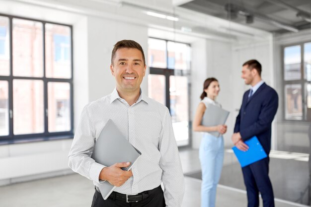 Immobilienmakler mit Ordner und Kunden im neuen Büro