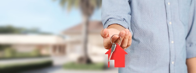 Immobilienmakler überreicht die Hausschlüssel in der Hand