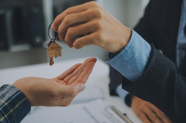 Immobilienmakler und Kunde unterzeichnen einen Vertrag zum Kauf einer Hausversicherung oder eines Immobilienkredits.