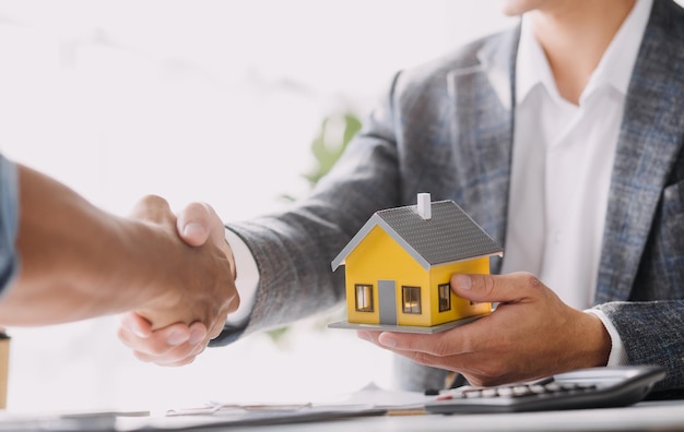 Immobilienmakler und Kunde unterzeichnen einen Vertrag zum Kauf einer Hausversicherung oder zum Darlehen von Immobilien