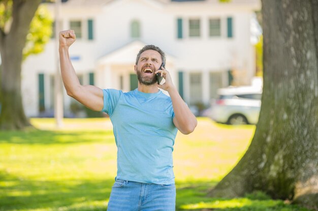 Immobilienversicherungsförderung erfolgreicher Makler Hypothekenversicherer amerikanischer Verkaufsleiter Immobilienmakler bei Haus zum Verkauf Makler hat Gespräch am Telefon Miete oder Kauf neues Zuhause Hausversicherung