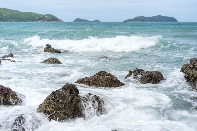 Impacto de grandes olas del océano contra rocas y piedras grandes.