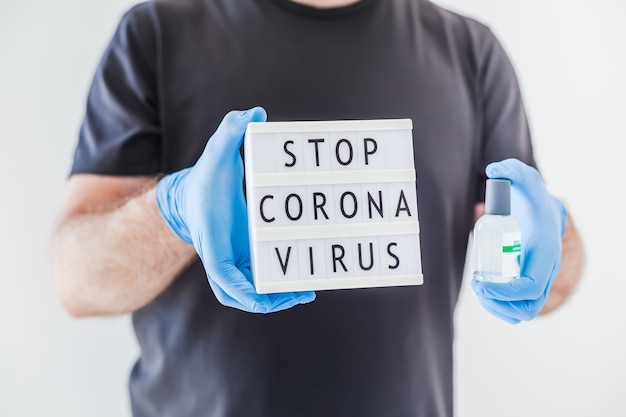 Impedir o texto do Coronavírus nas mãos de um homem usando luvas médicas de látex