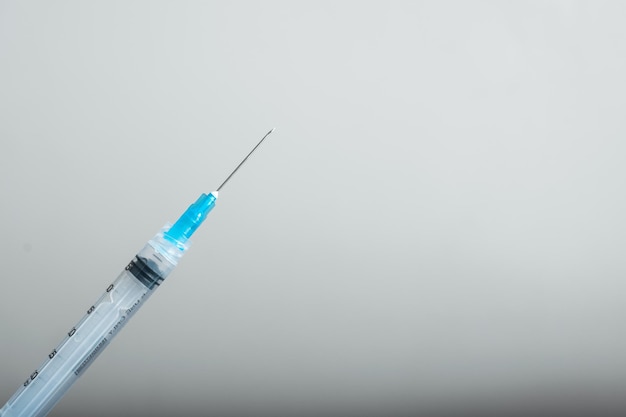 Impffertige Spritze von unten links kommend, Impf- und Schutzinstrumente