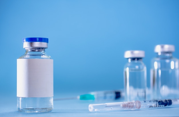 Foto impfstoff und spritze medizinisch in blauer umgebung