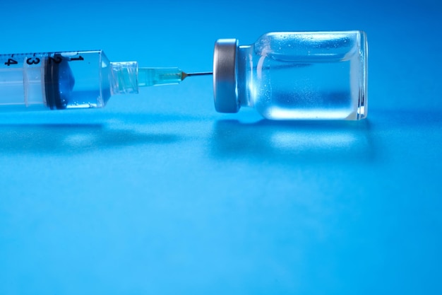 Impfstoffflasche auf blauem Hintergrund
