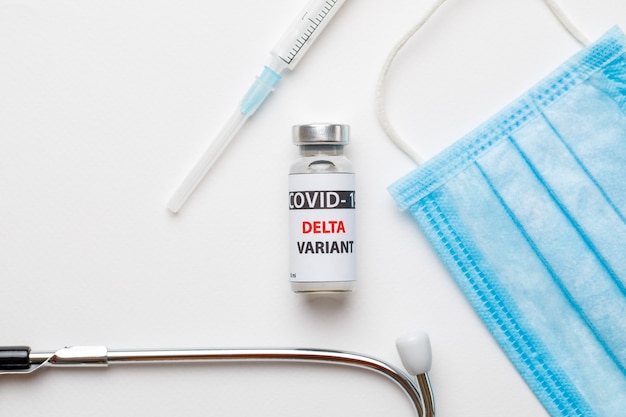 Foto impfstoffflaschen covid - 19 delta-variante, fläschchen medizin und spritzeninjektion einzeln auf weiß. coronavirus delta 2019-ncov.