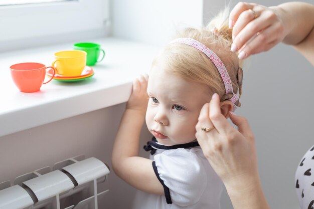 Implante coclear no conceito de aparelho auditivo e surdez de cabeça de bebê