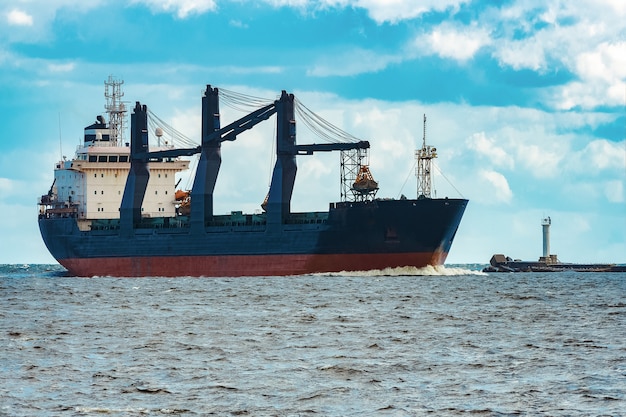 Importação de mercadorias. grande navio de carga azul movendo-se para o porto de riga
