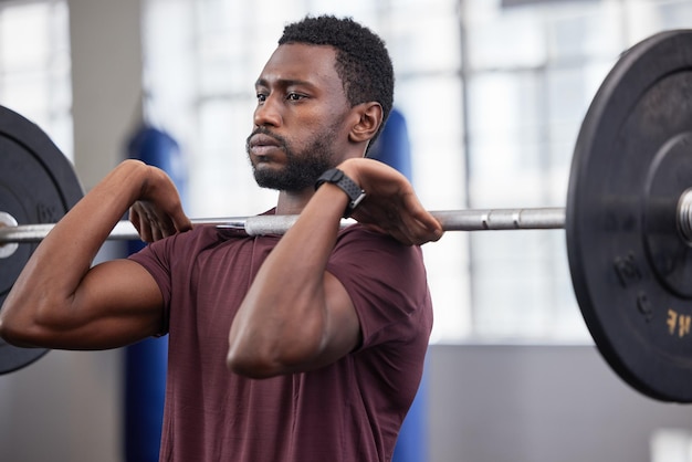 Imprensa aérea com barra de homem forte e treino de ginástica e treinamento funcional em clube esportivo Fisiculturista de homem negro e desafio de levantamento de peso com pesos pesados, foco e motivação