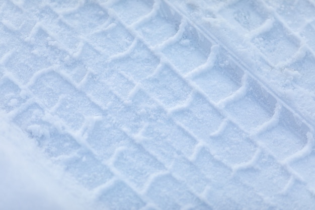 Impresión de neumáticos de coche en la nieve de cerca