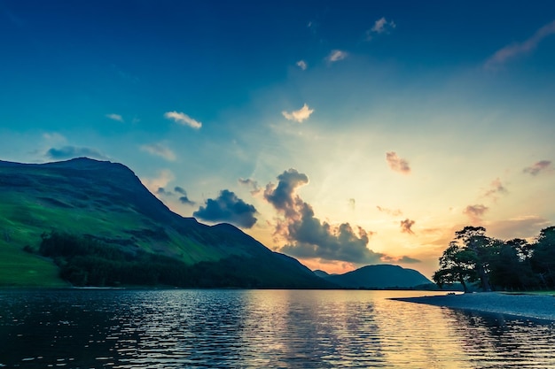 Impresionante atardecer colorido en el lago en el distrito de Lake England