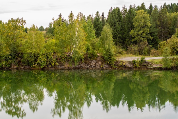 Impresionante foto del follaje de otoño reflejada en un lago con una superficie de agua de vidrio como espejo.