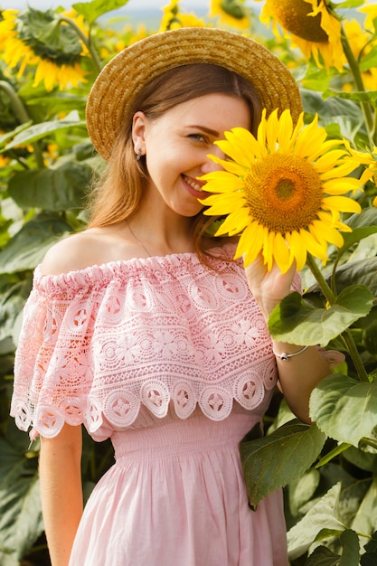 Impresionante foto, hermosa joven rubia de pie entre los girasoles