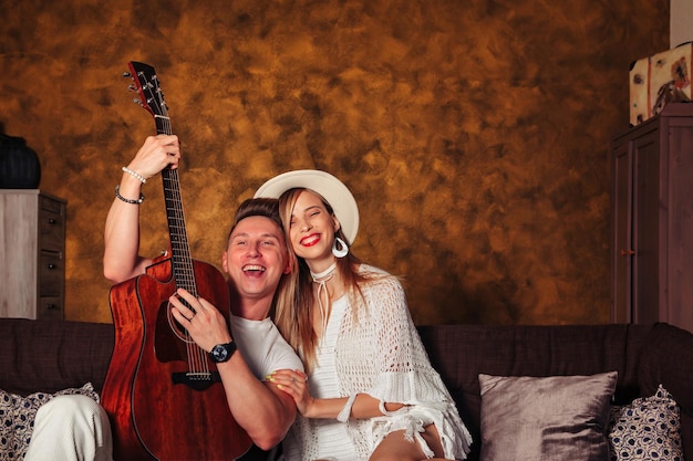 Impresionante joven y mujer vestidos de blanco con guitarra