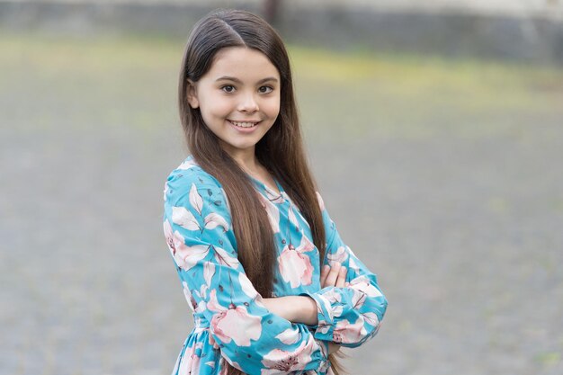 Impresionante niña Niña feliz con linda sonrisa al aire libre Aspecto de moda de niña Niña pequeña con peinado largo Salón de belleza Moda y estilo Infancia y juventud Día internacional del niño