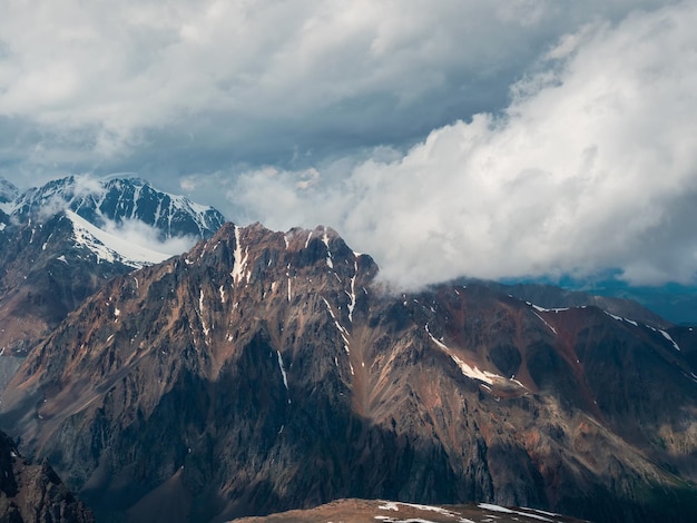 Impresionante nube oscura en la cima de la montaña Maravilloso paisaje dramático con grandes picos nevados sobre nubes bajas Atmosféricas cimas de grandes montañas nevadas en el cielo nublado