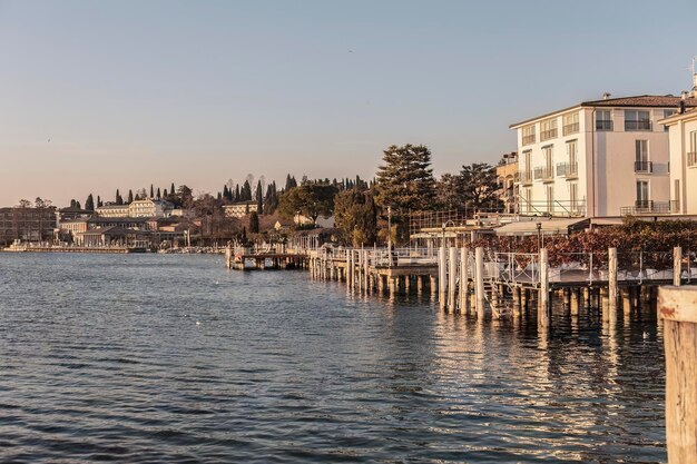 Foto impresionante paisaje al atardecer en sirmione una vista perfecta de la costa y el muelle