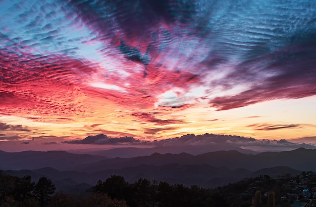 Impresionante paisaje de montaña con una puesta de sol vívida y colorida en el cielo brillante fondo natural de viajes al aire libre Vista panorámica