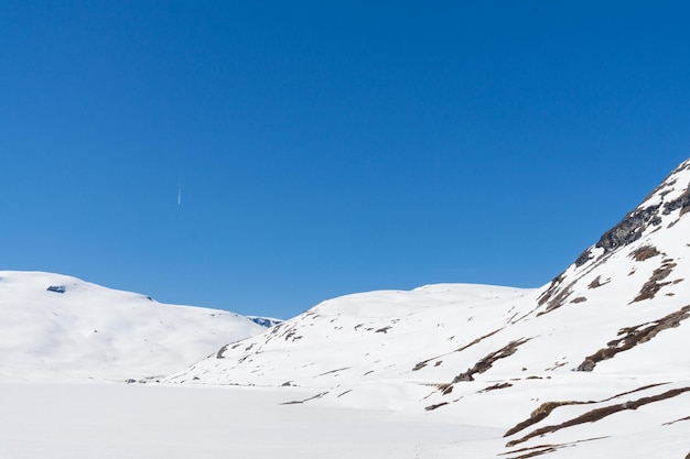 Impresionante paisaje nevado de un lago y sus montañas Noruega