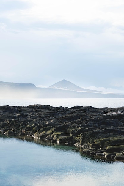 Impresionante paisaje de pico de montaña cerca del mar en un día de niebla en las Islas Canarias